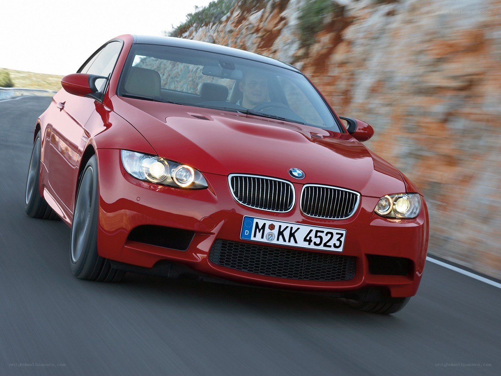 red bmw m3 driving on road