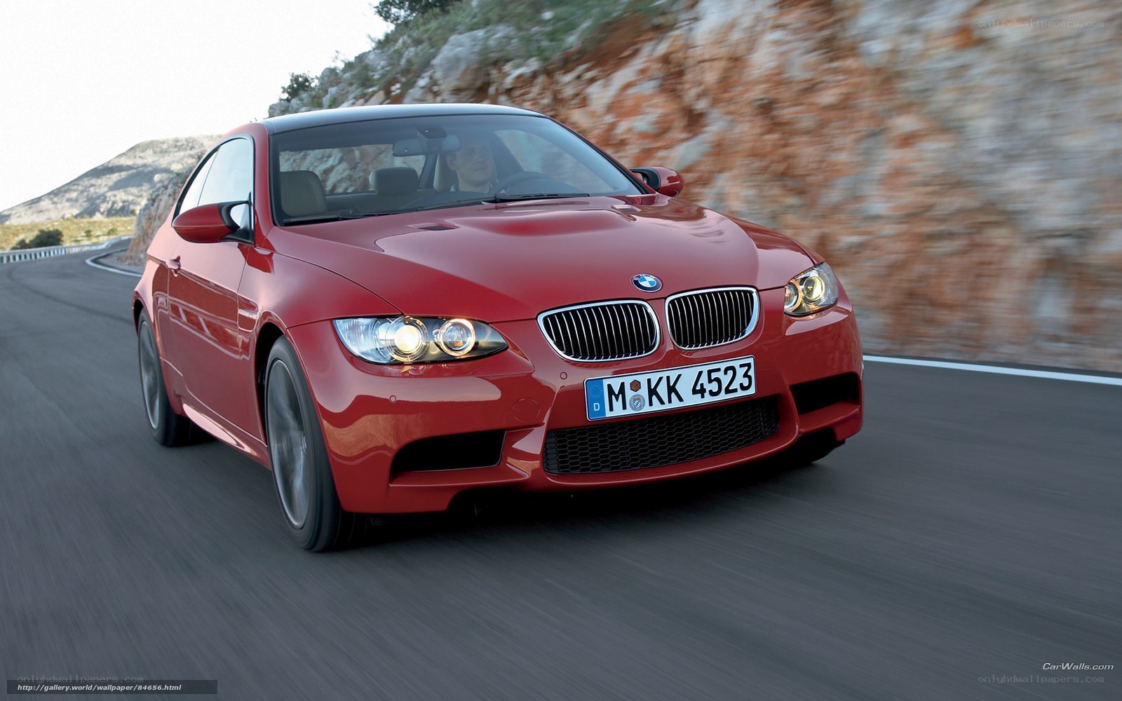 Red BMW M3 driving on road