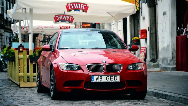 Red BMW M3 on a cobblestone street