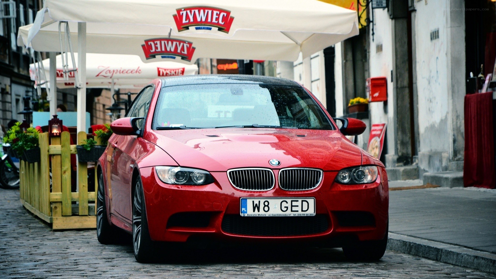Red BMW M3 on a cobblestone street