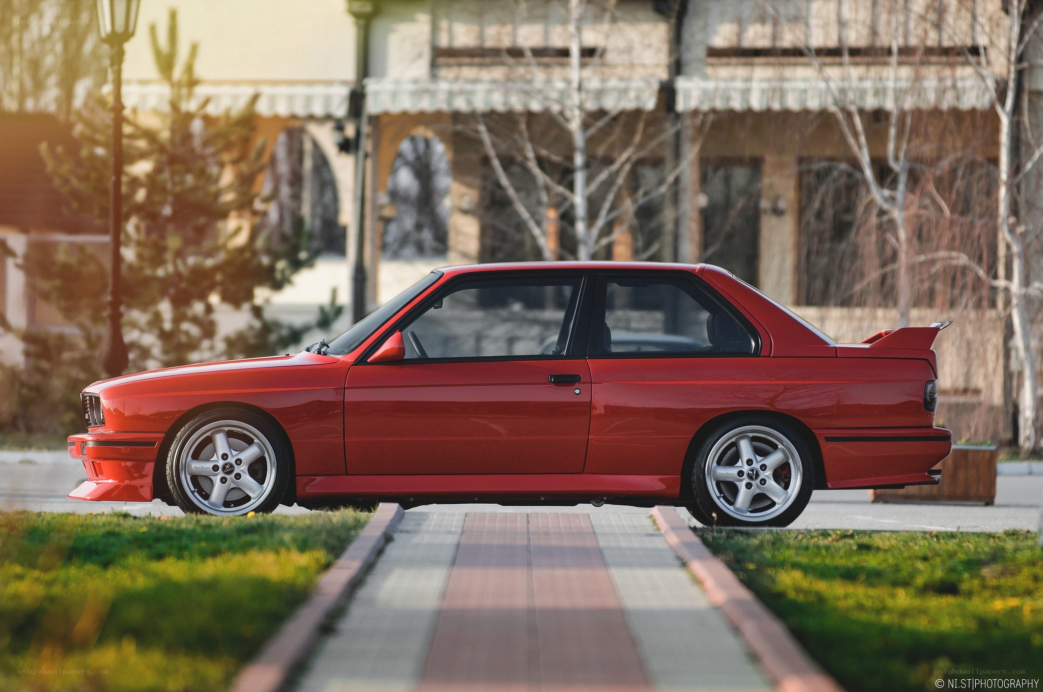 Red BMW M3 on a sidewalk