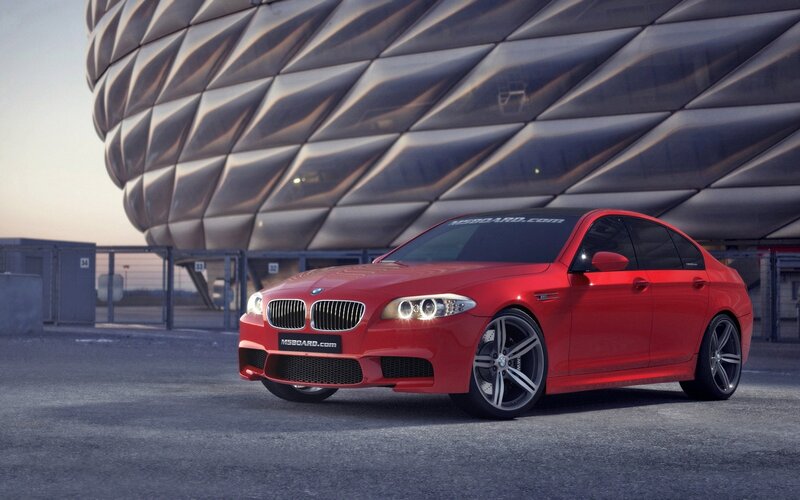 Red BMW M5 in front of stadium