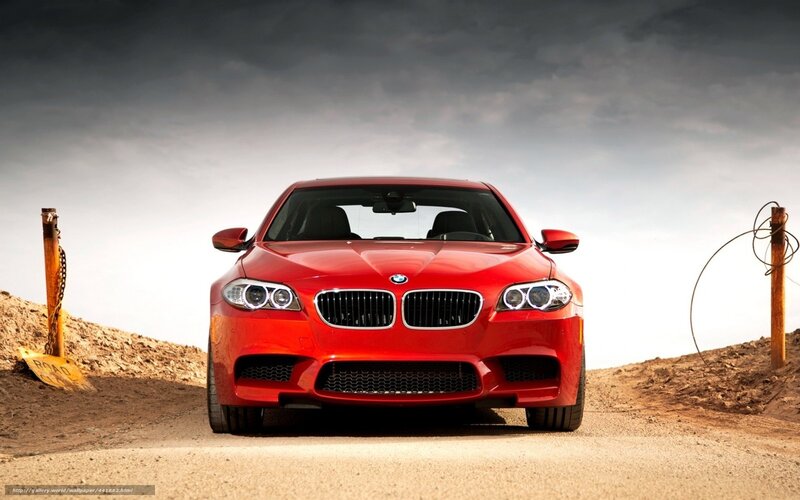 Red BMW M5 on a dirt road