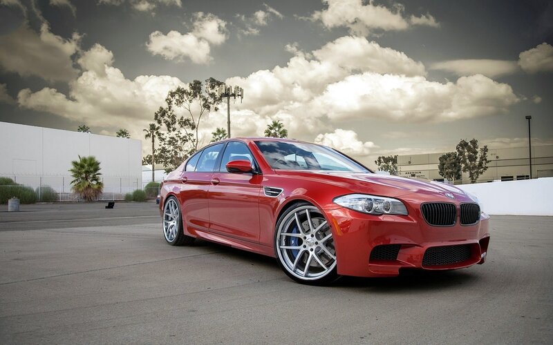 Red BMW M5 on a paved lot