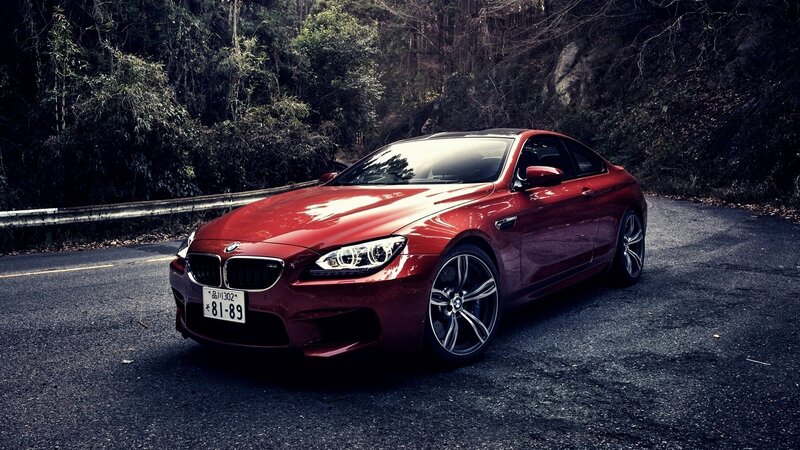 Red BMW M6 on a forest road