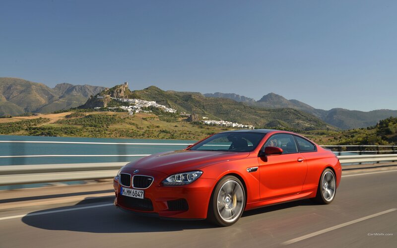 Red BMW M6 on a scenic road