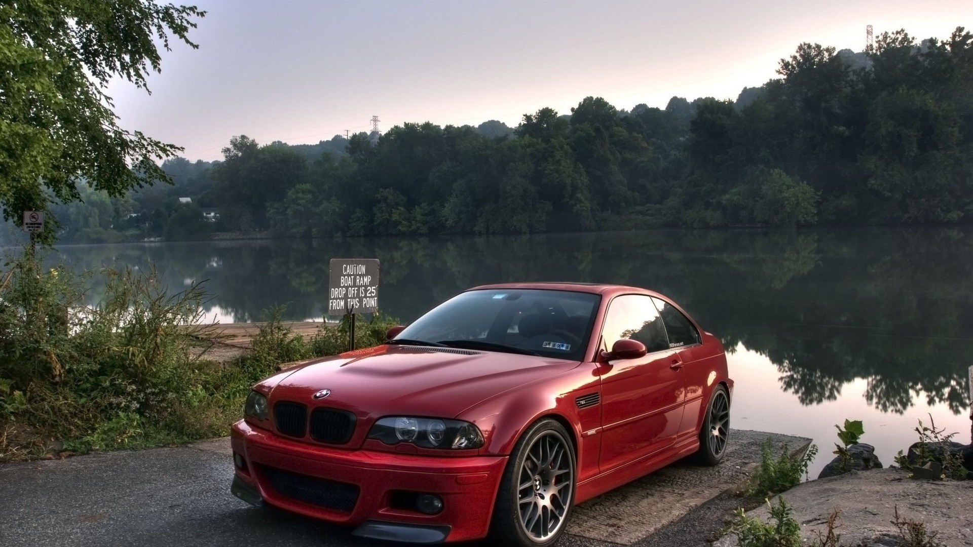 Red BMW on a lakeside road