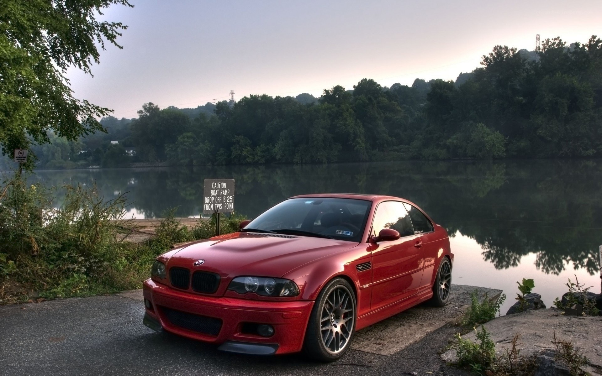Red BMW on a lakeside road