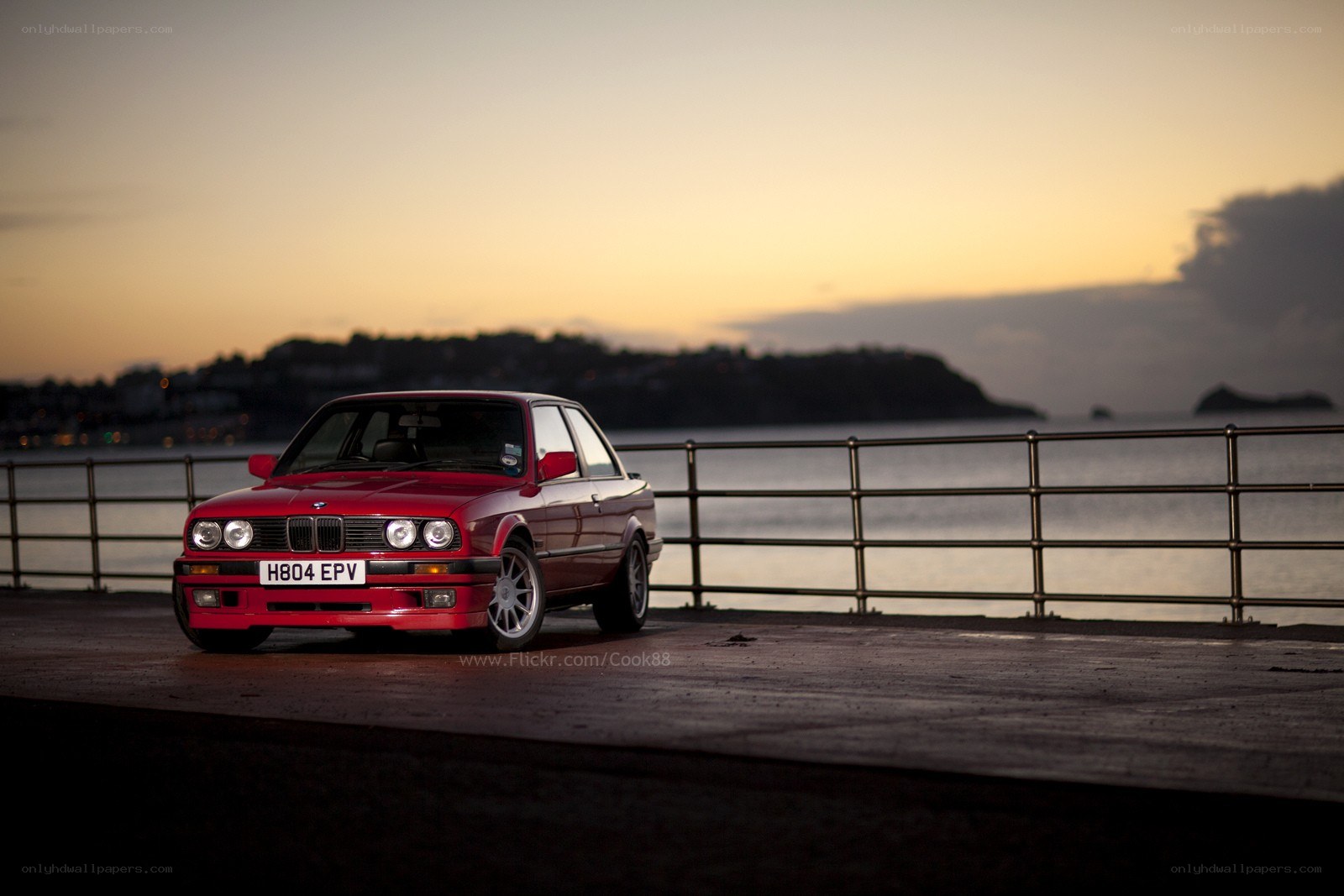 Red BMW on a pier at sunset