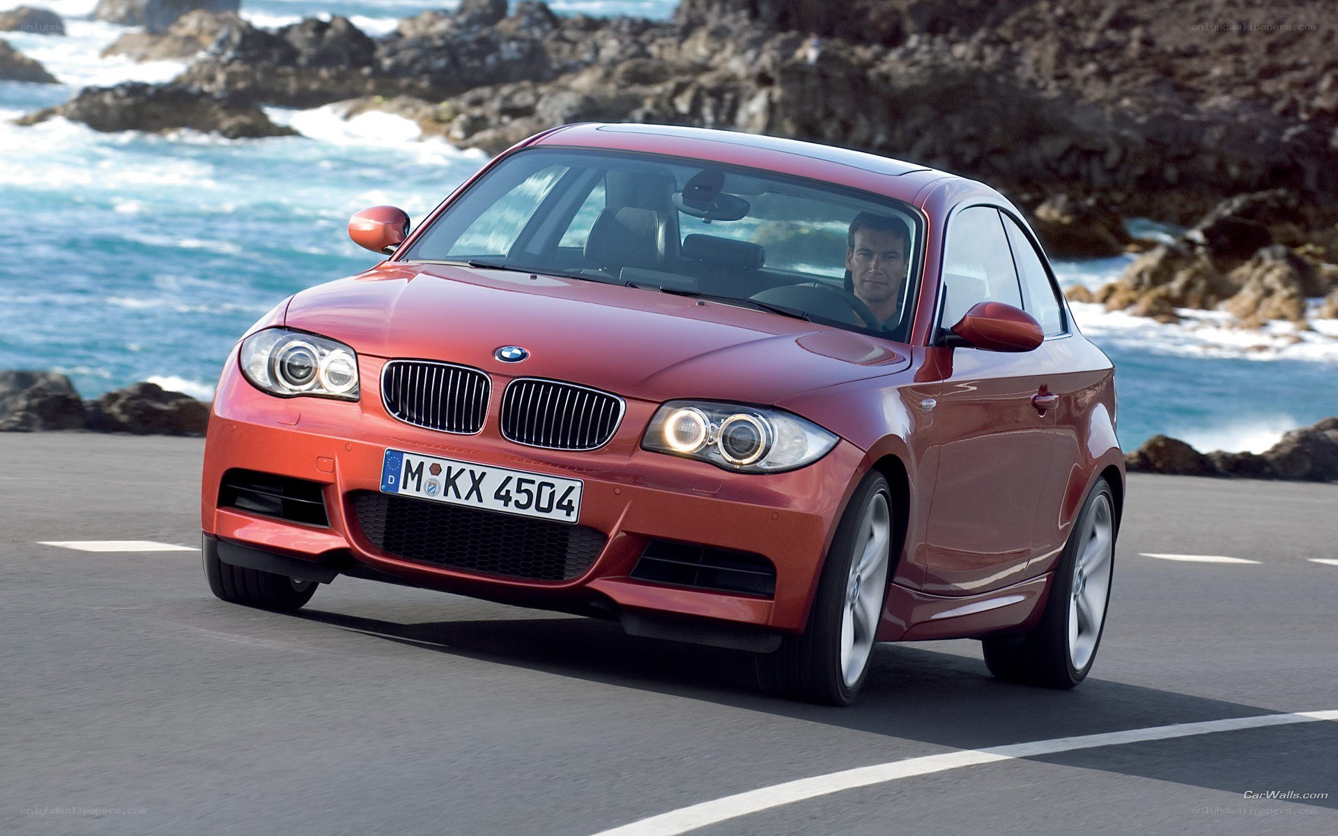 Red BMW on coastal road