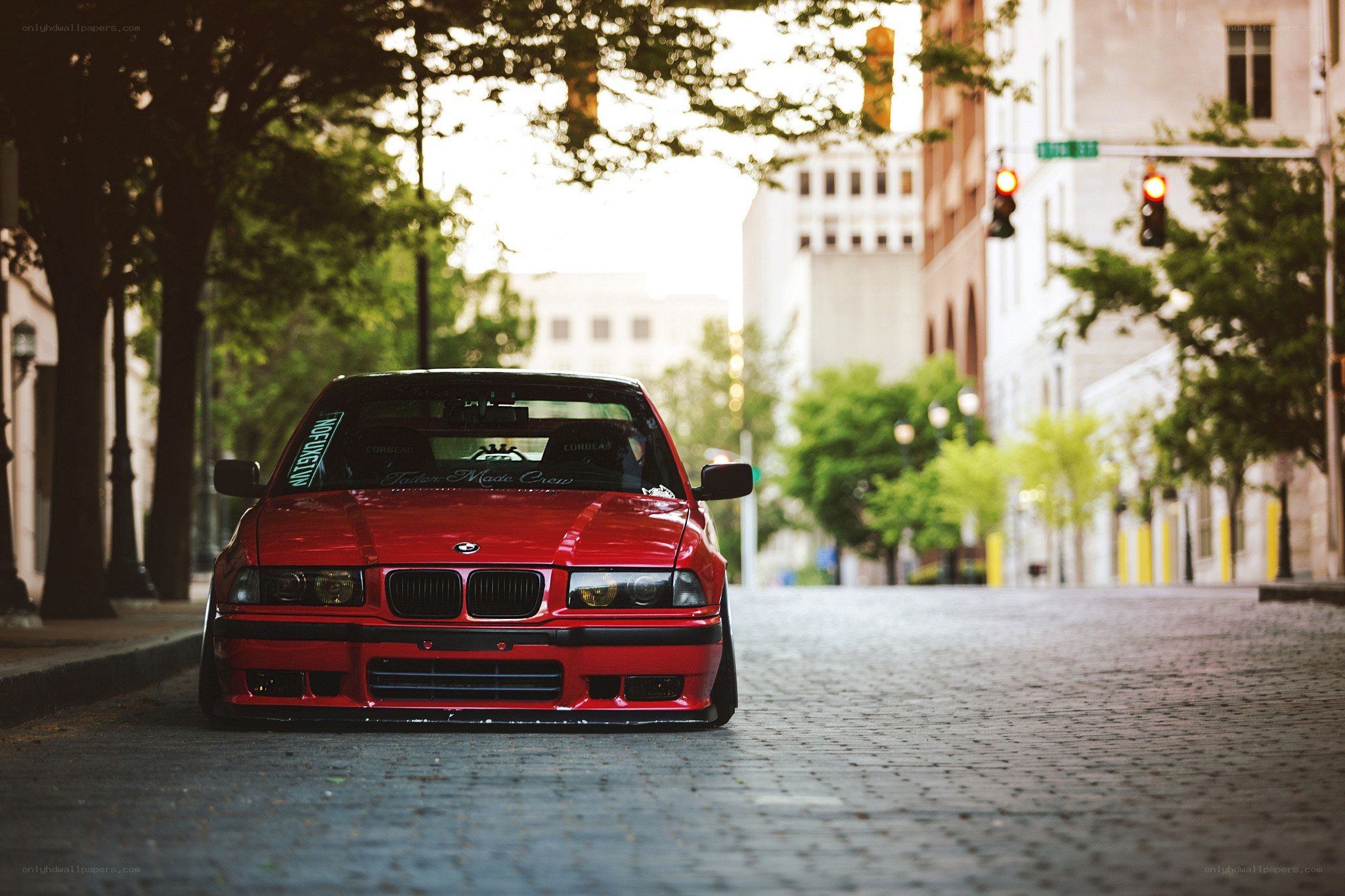 Red BMW on cobblestone street
