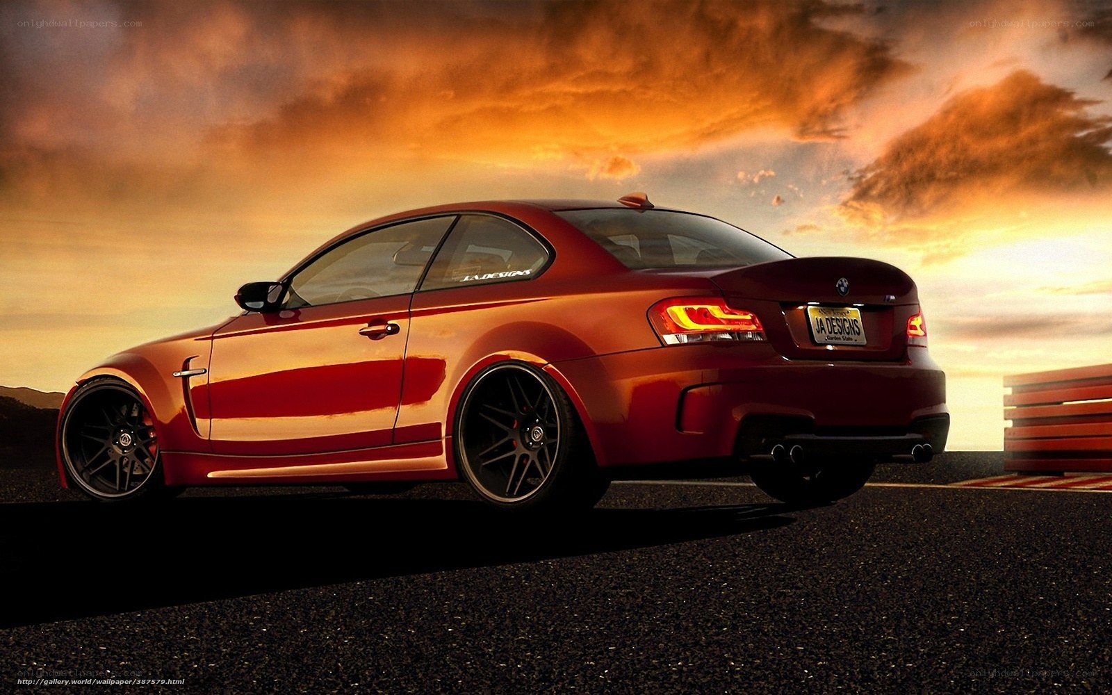 Red BMW on racetrack at sunset