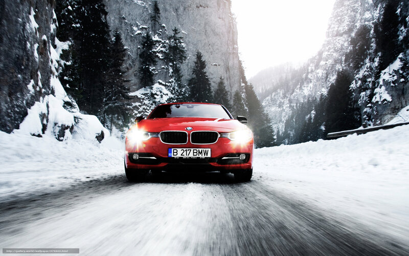Red BMW on snowy mountain road