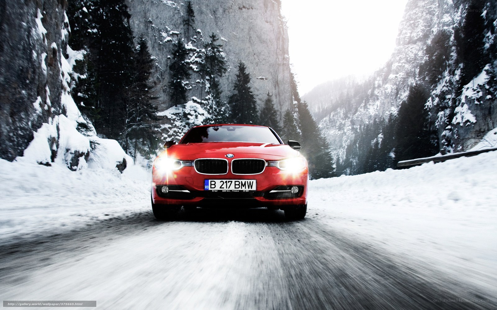 Red BMW on snowy mountain road
