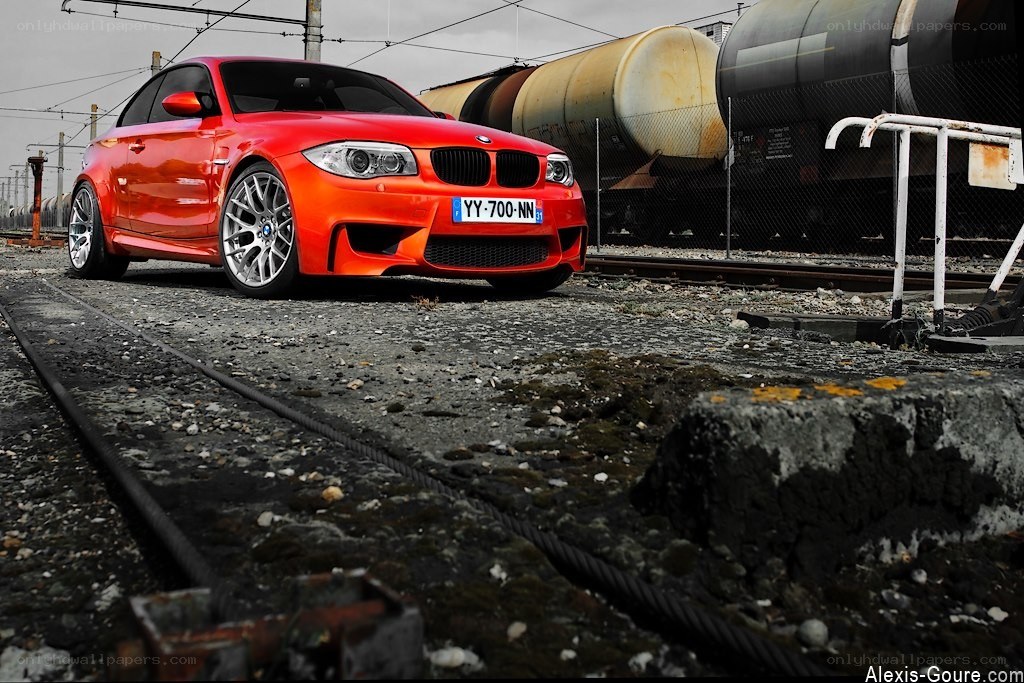 Red BMW on train tracks