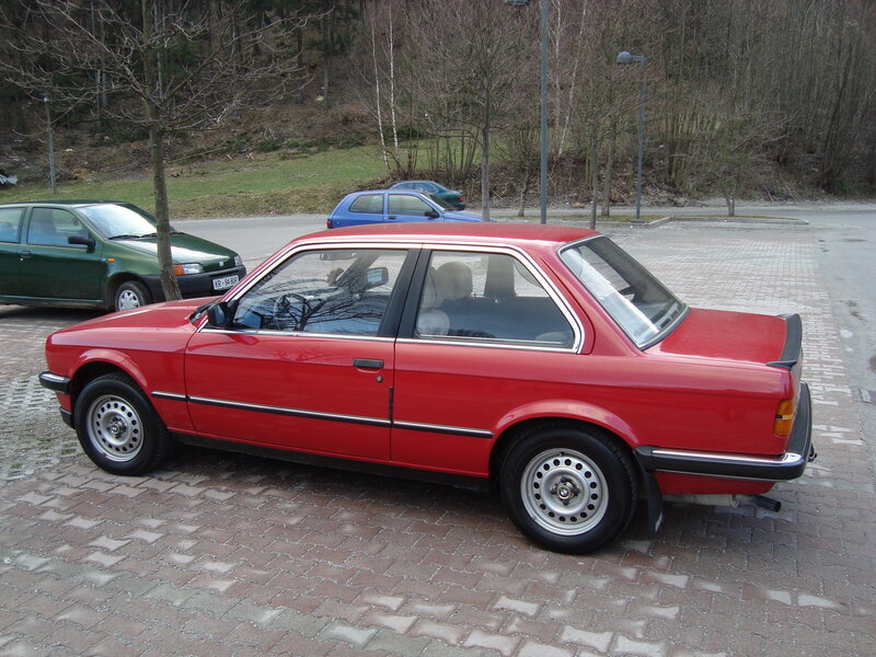 Red BMW parked on bricks