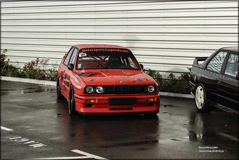 Red BMW race car on wet pavement