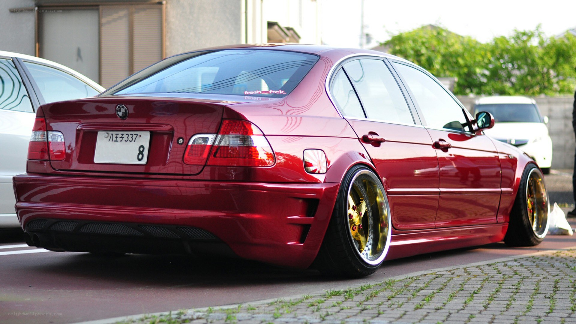 red bmw sedan with gold wheels