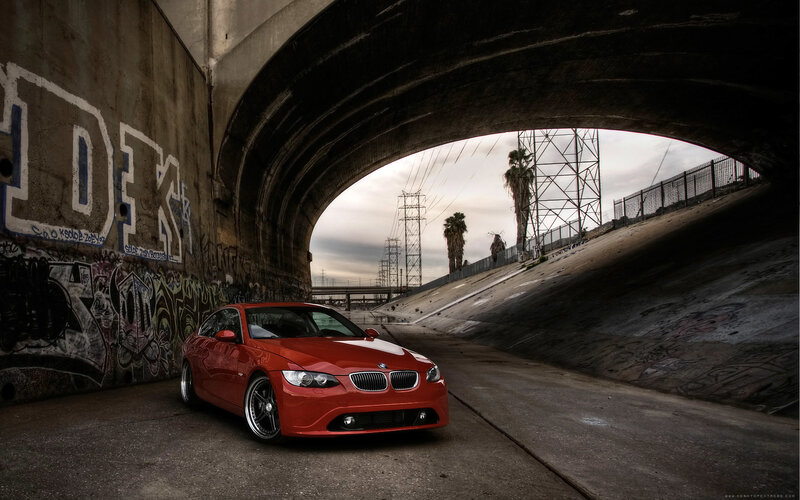 Red BMW under a bridge