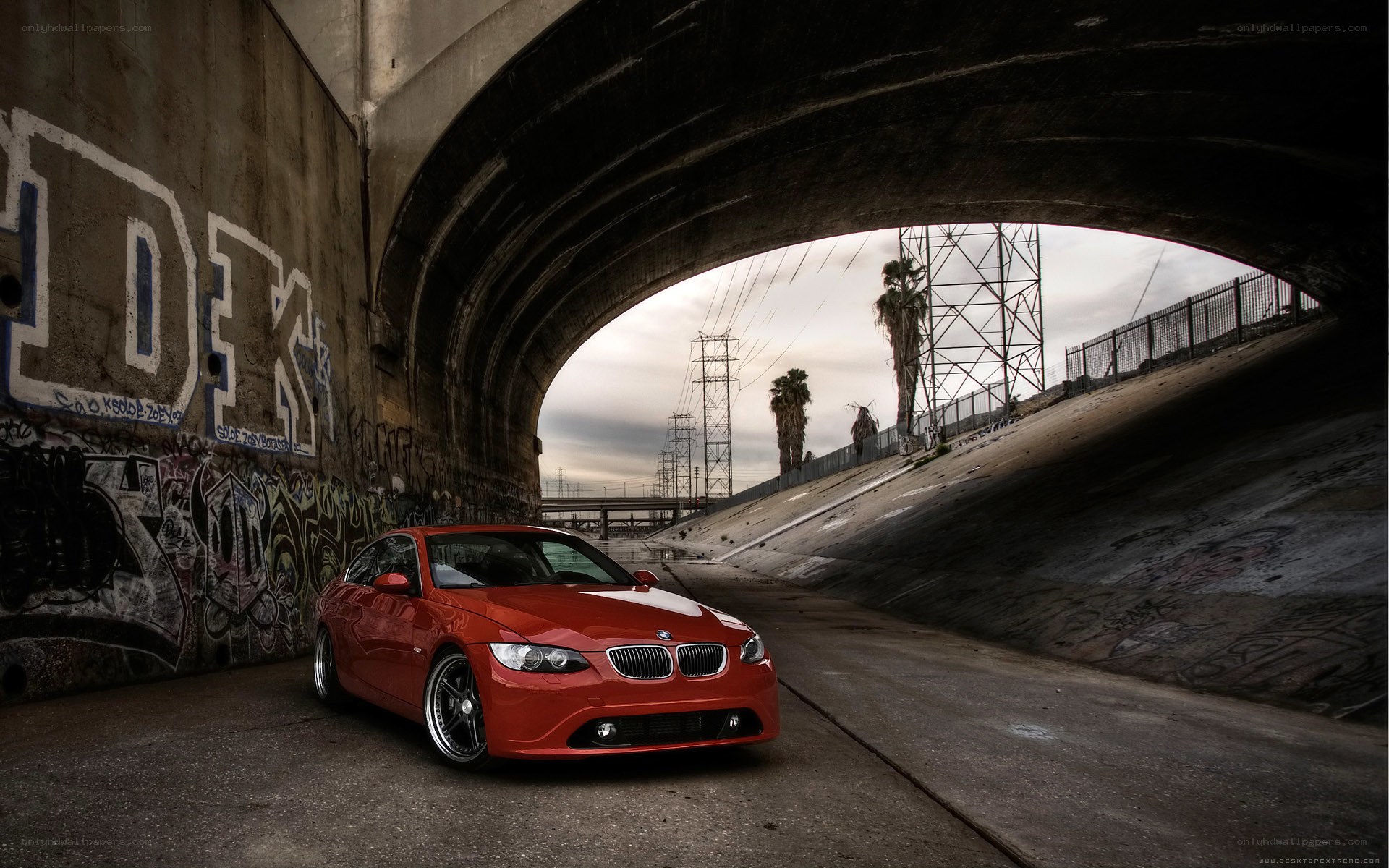 Red BMW under a bridge