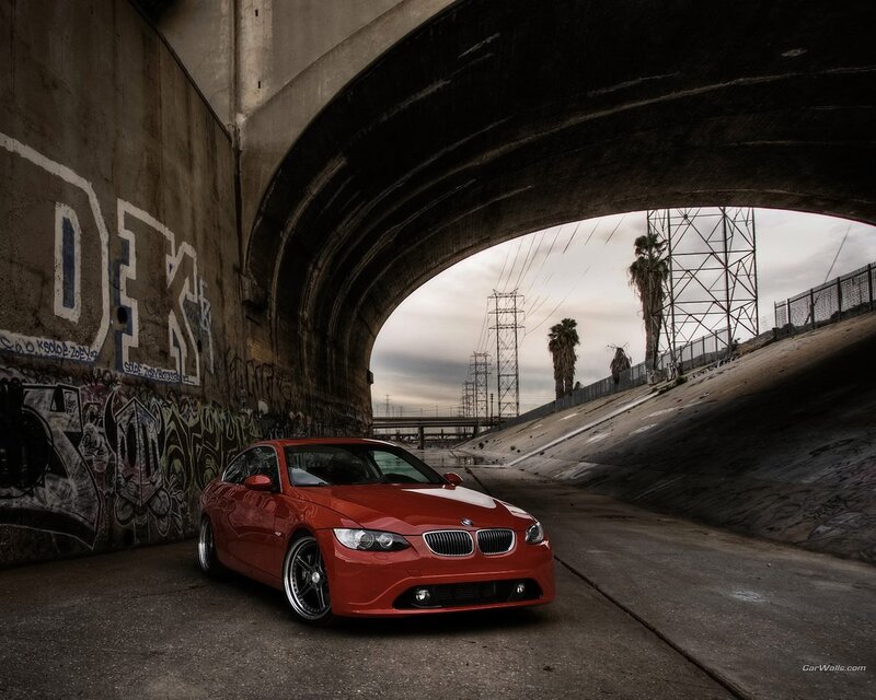 Red BMW under a bridge