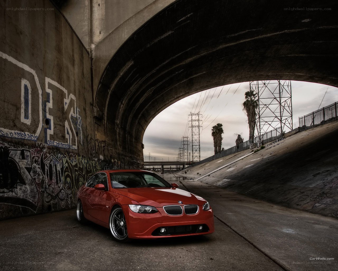 Red BMW under a bridge