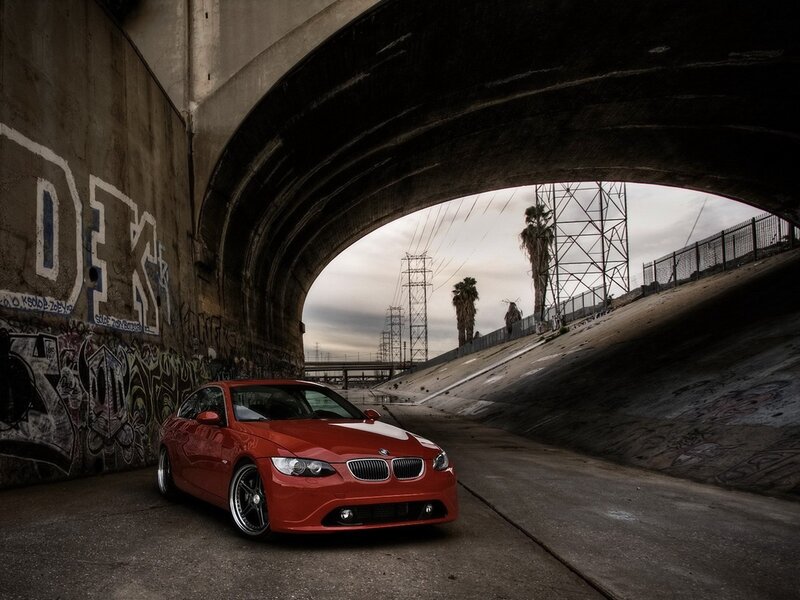 Red BMW under a bridge