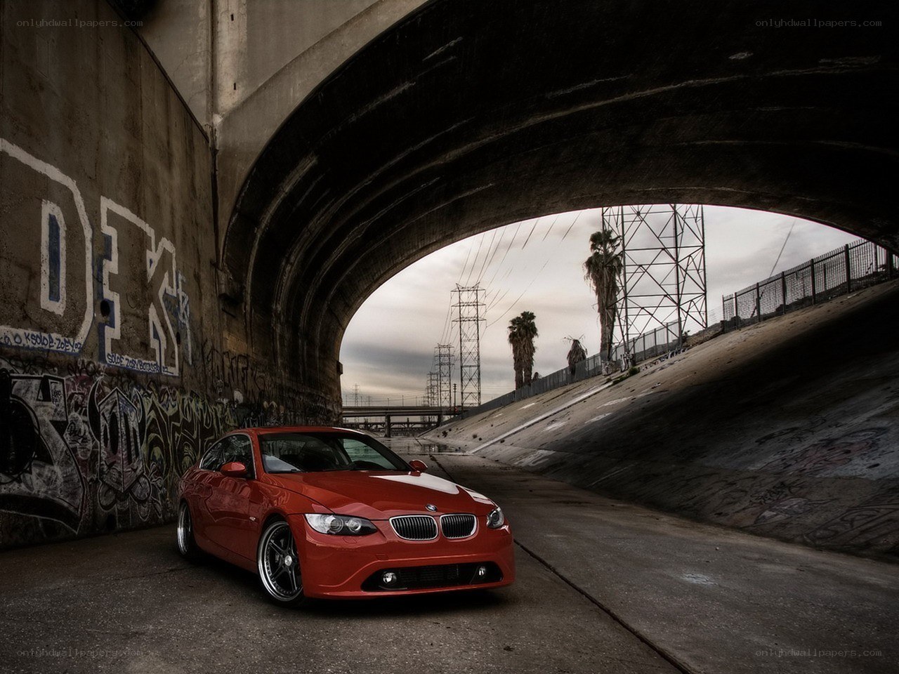 Red BMW under a bridge