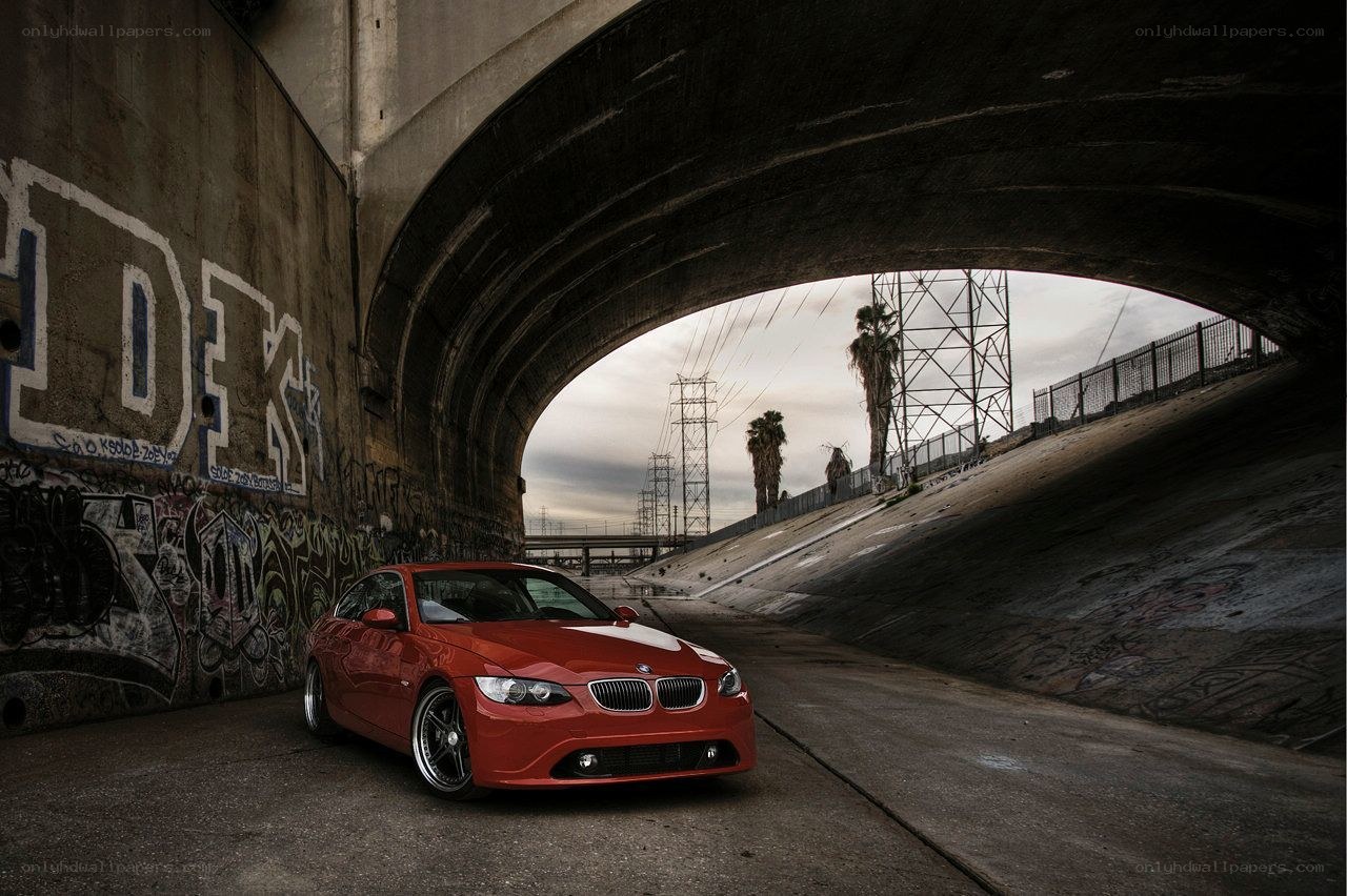 Red BMW under a bridge