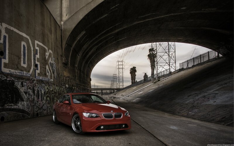 Red BMW under a bridge