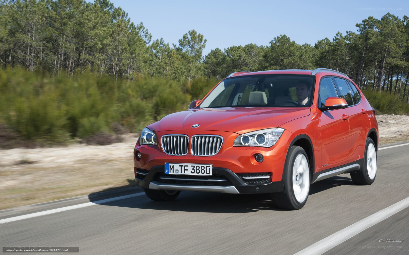 Red BMW X1 driving on road