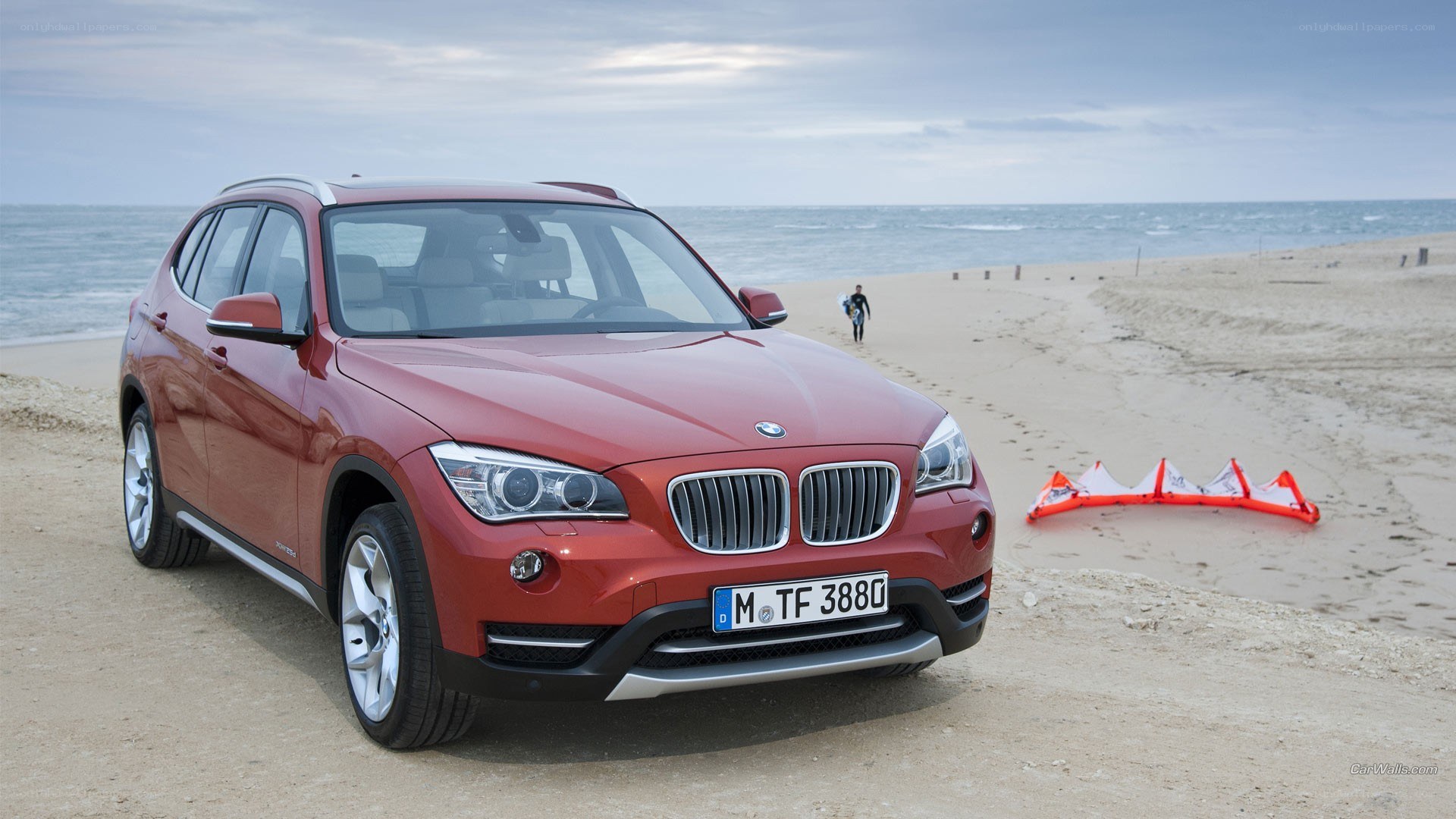 Red BMW X1 on a beach