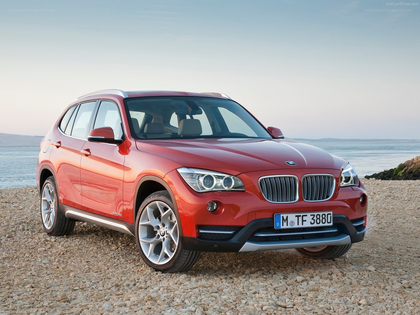 Red BMW X1 on a pebble beach