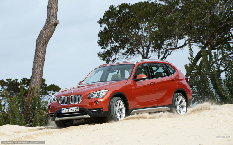 Red BMW X1 on sandy beach
