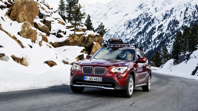 Red BMW X1 on snowy mountain road