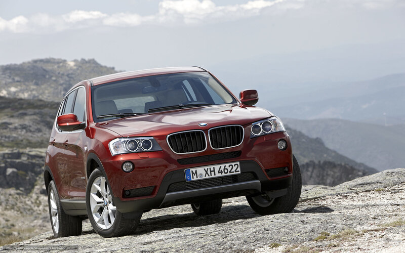Red BMW X3 on rocky terrain