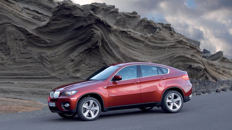 Red BMW X6 in a rocky landscape