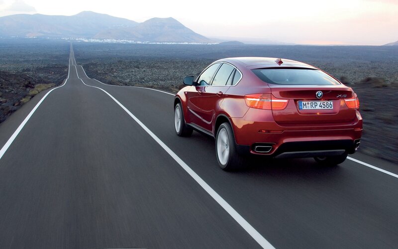 Red BMW X6 on a desert road