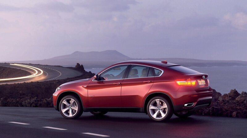 Red BMW X6 on coastal road