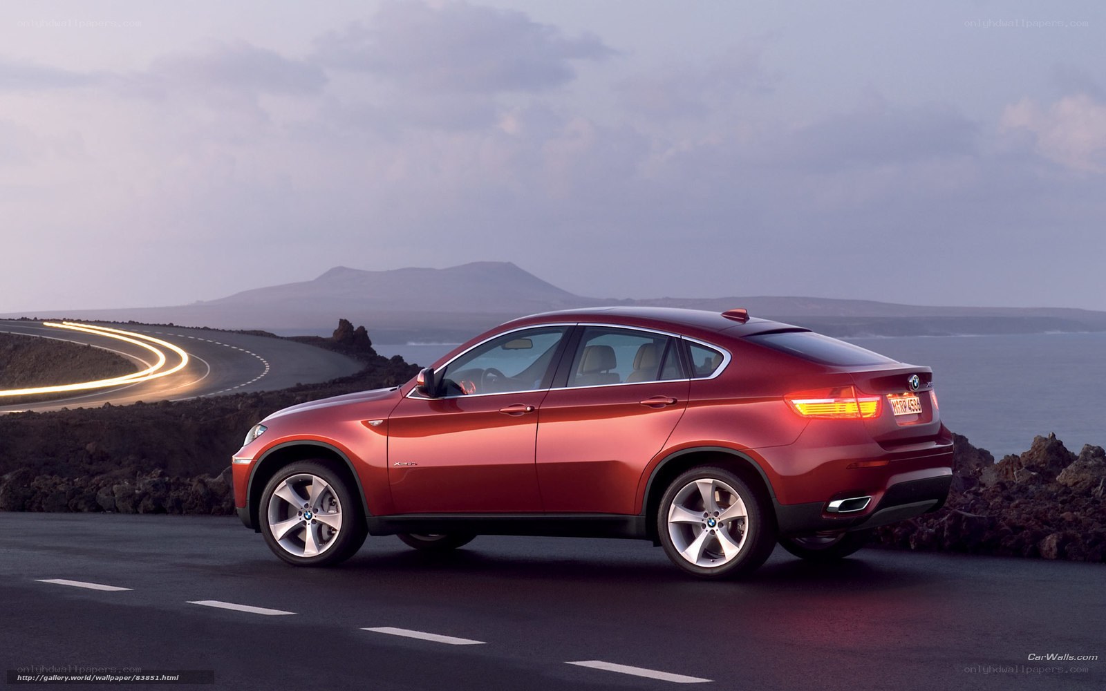 Red BMW X6 on coastal road