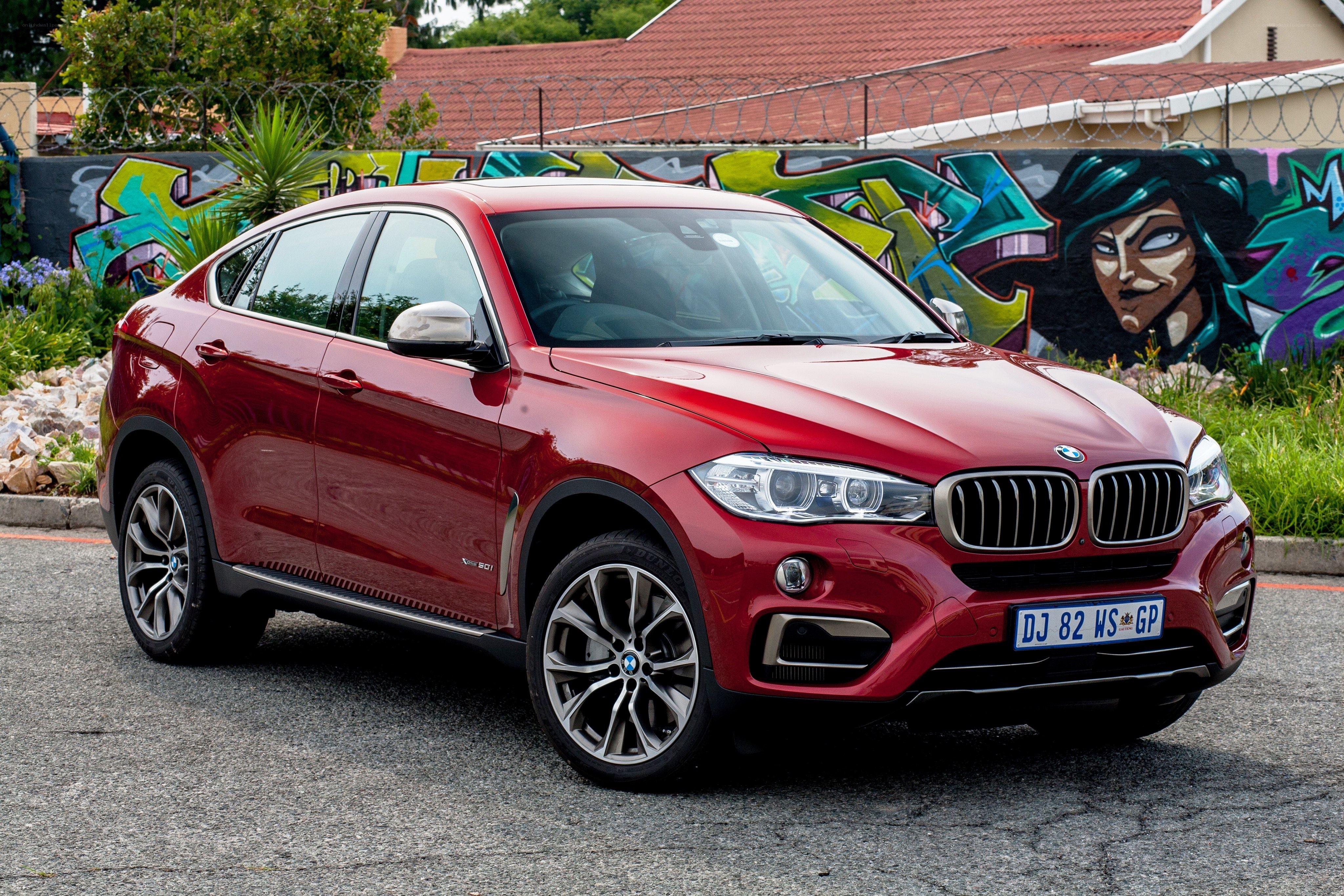 Red BMW X6 parked in front of graffiti