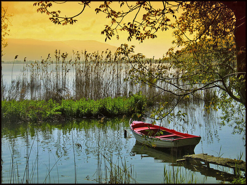 Red boat at sunset on a lake