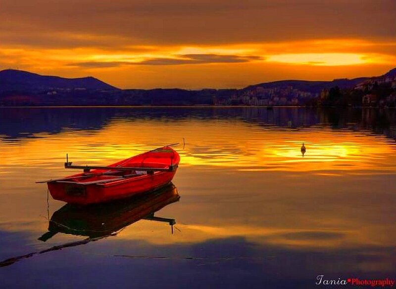 Red boat at sunset on lake