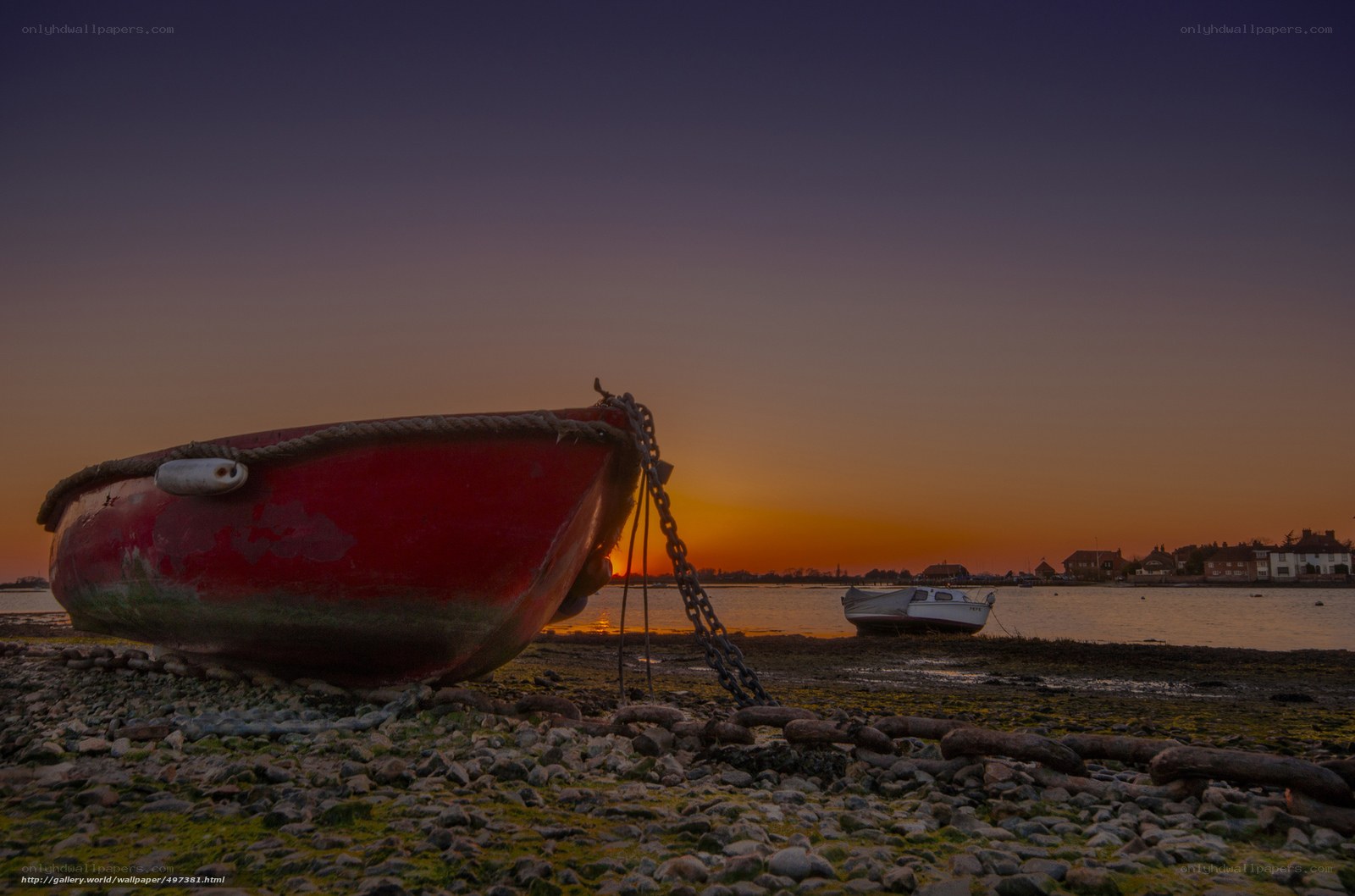 Red boat at sunset on shore