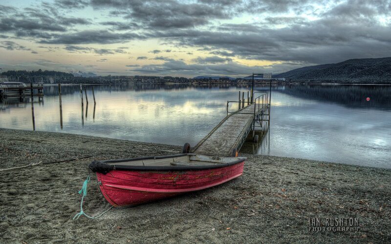 Red boat on a lake shore