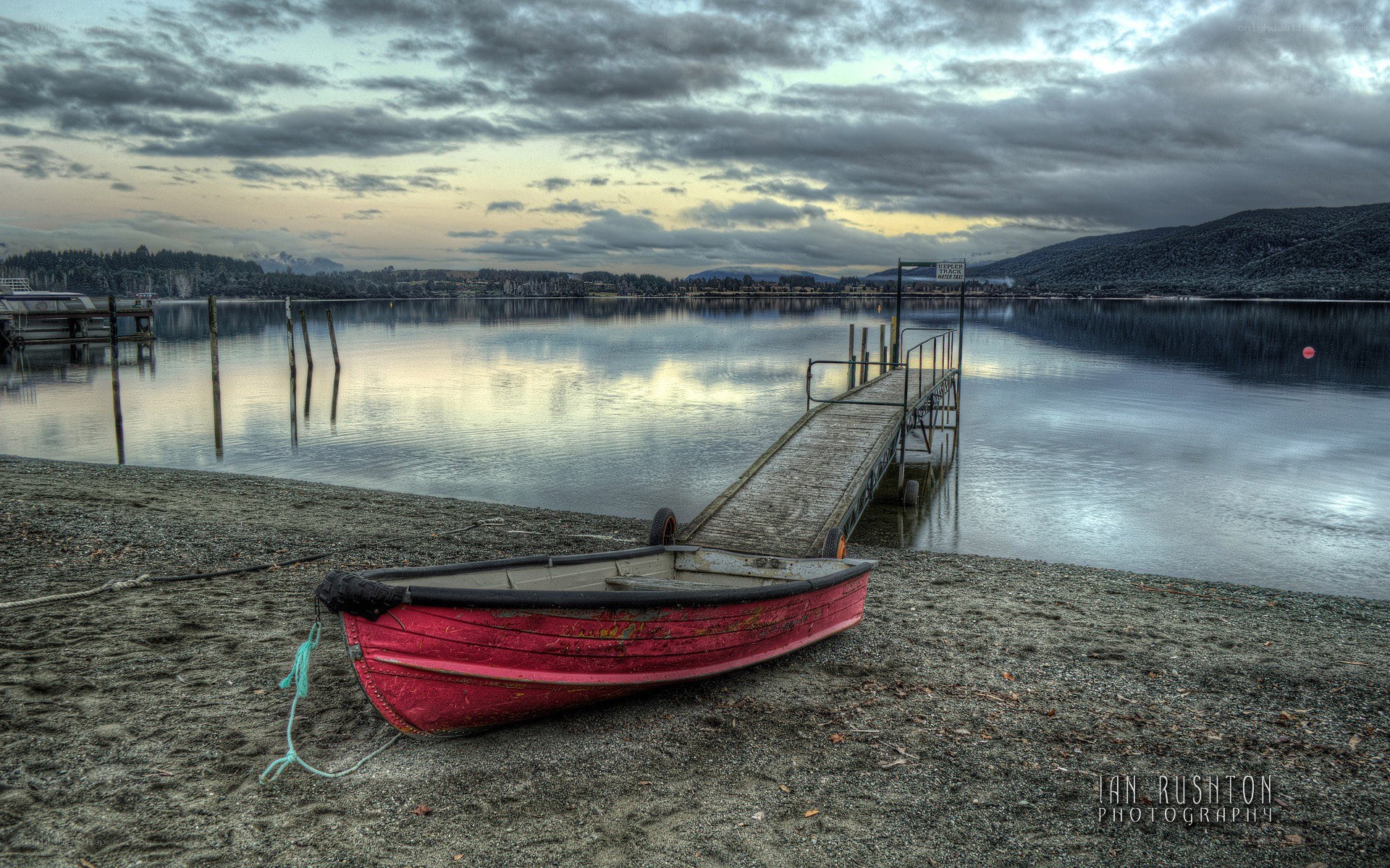 Red boat on a lake shore