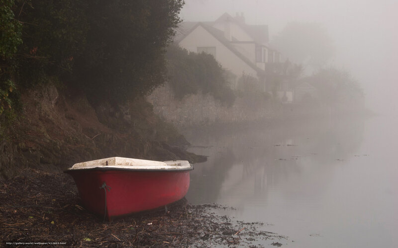 Red boat on misty riverbank