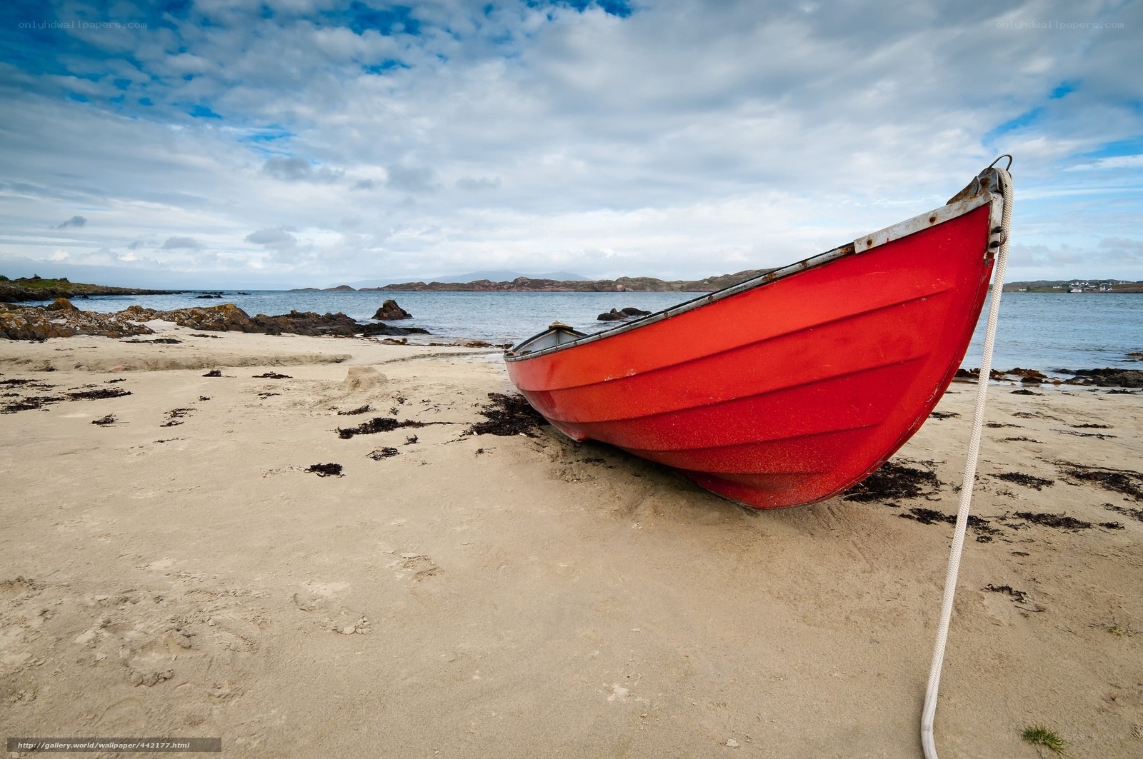Red boat on sandy beach