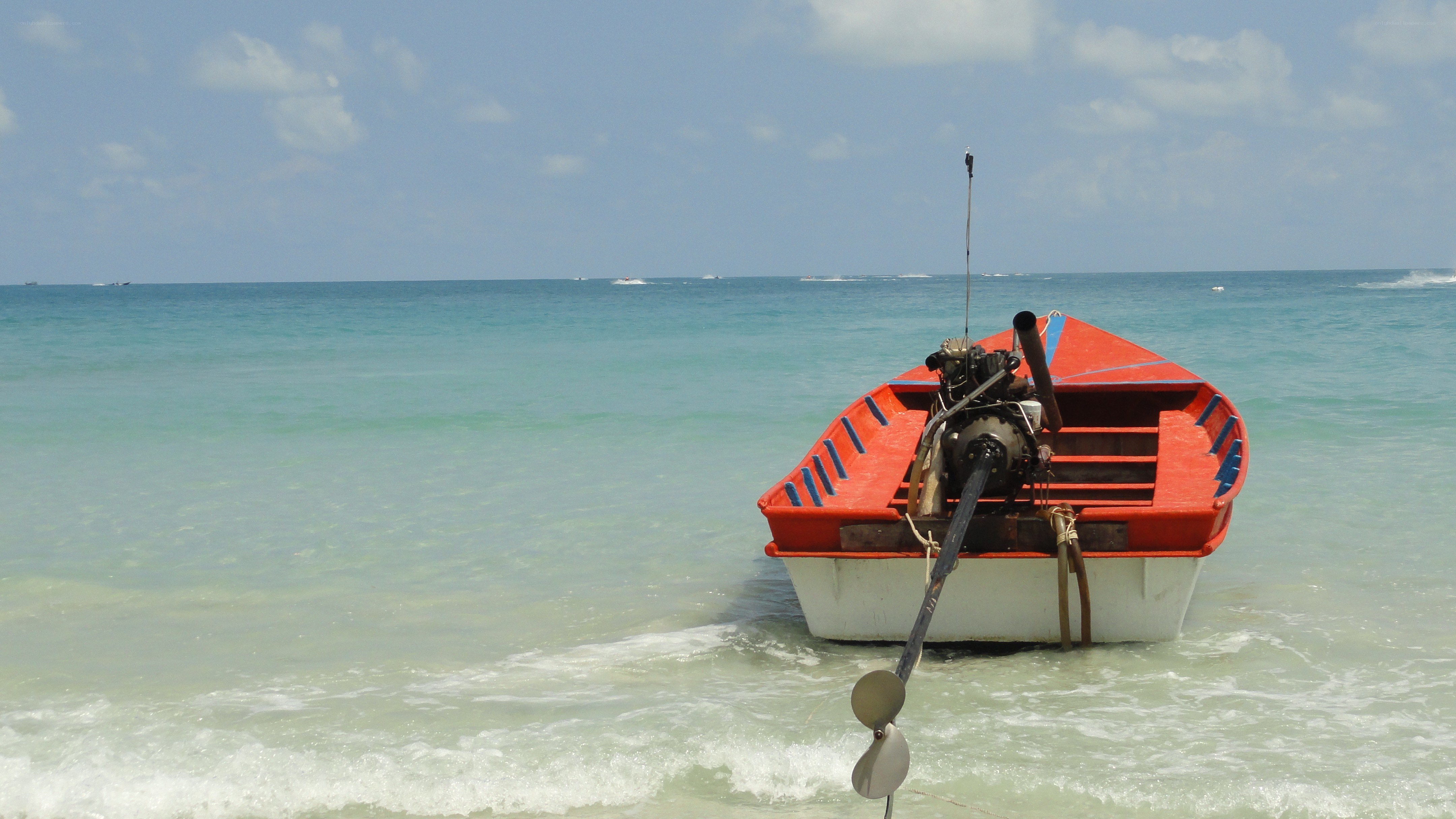 Red boat on tropical beach