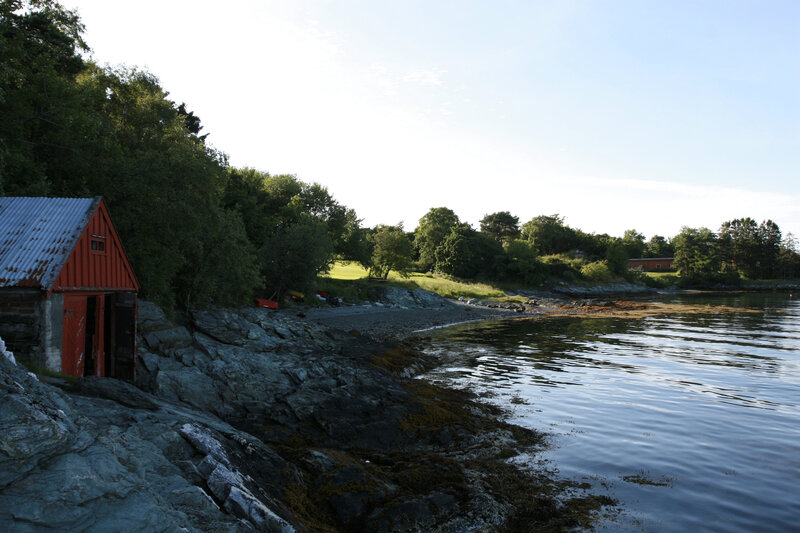 Red Boathouse on Rocky Shore — Serene